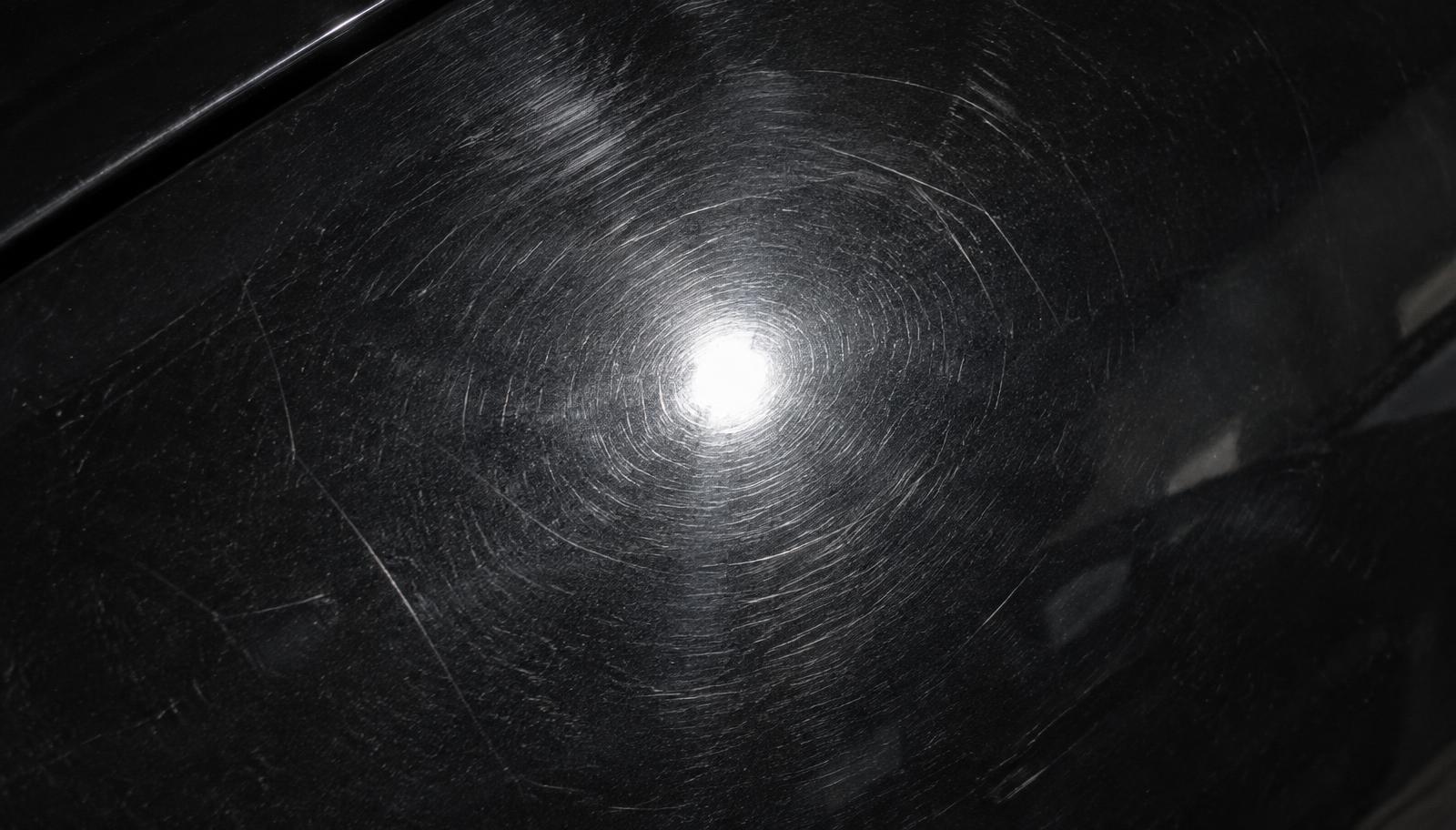 Swirl marks and fine scratches on a dark car panel before three-stage paint correction in Bolingbrook, IL
