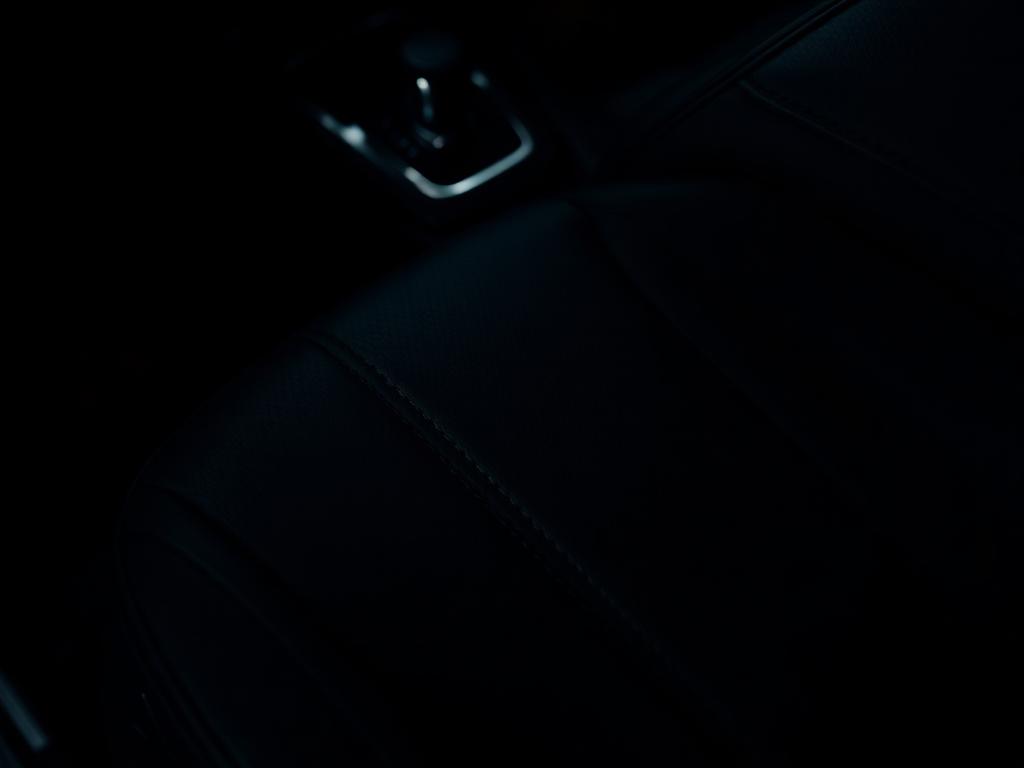 Conditioned black leather seat and dashboard detail after interior restoration
